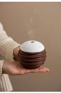 Nahaufnahme des Keramik-Räucherfasses mit geripptem braunem Boden und gesprenkeltem weißem Top.
