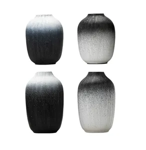 Detailed view of minimalist black white gradient resin vases with vertical texture.