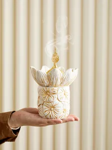 Detail shot of the white and gold lotus flower incense burner jar, elegant crafted decor.