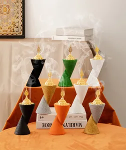 Detailed view of creative double cone resin incense burners with hollow gold lids and smoke.