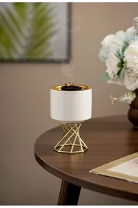 Modern Nordic ceramic incense burner detail, white pot with gold metal stand for home decor.