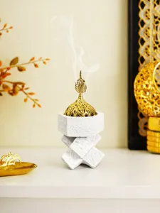 Detailed view of the resin incense burner with gold filigree lid and smoke effect.