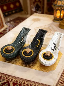 Detailed shot of resin flat boat Arabic incense burners with calligraphy, set of three.