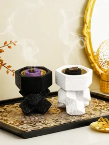 Detailed view of creative resin cross-knot incense burners in black and white styles.