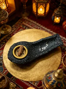 Detail view of Arabic calligraphy resin boat incense burner, traditional Middle Eastern decor scene.