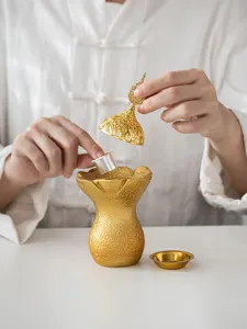 Vue détaillée d'un brûleur d'encens doré du Moyen-Orient en résine avec couvercle ajouré.
