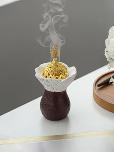 Gros plan détaillé d'un brûleur d'encens en résine du Moyen-Orient créatif avec couvercle doré.