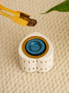 Close-up of a creative heart-shaped ceramic incense burner with blue and gold accents.