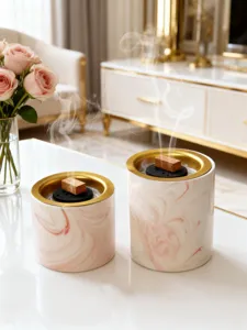 Nahaufnahme des luxuriösen rosa Marmor Keramik Räucherfasses mit Goldrand und Rauch.