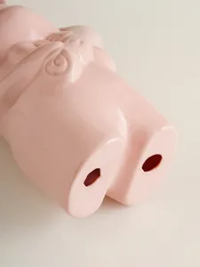 Primer plano detallado del florero de conejo de cerámica rosa con textura de esmalte.