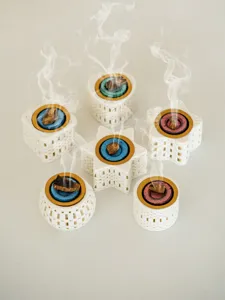 Detail shot of creative 3d printed ceramic incense burners in various geometric shapes with smoke.