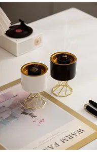 Modern ceramic incense burner with gold metal stand, stylish home aromatherapy decor.