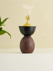 Vista detallada del quemador de incienso creativo moderno con tapa de hoja dorada y base.