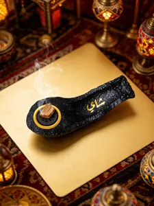 Detailed view of the resin boat incense burner with Arabic calligraphy for desktop decor.