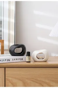 Primo piano del bruciatore di oli essenziali in ceramica minimalista moderna, chic.