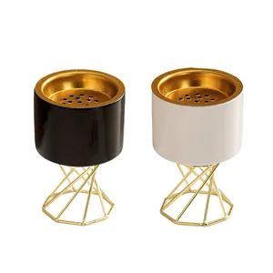 Close-up view of the ceramic incense burner with a sleek gold geometric metal stand.