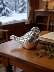 Charming silver glossy ceramic bird figurine detail, elegant desktop decoration for home.