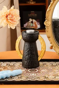 Candeliere in resina con doppia maniglia dorata dettaglio, decoro tavola nero