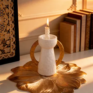 Portacandele in resina dorata con due manici e candela profumata per decorazione tavola.