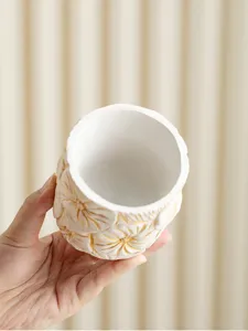 Handheld white and gold floral censer jar detail, elegant Arabic aromatherapy burner.