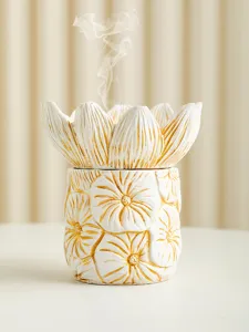 Detailed close-up of a white and gold lotus flower incense burner with delicate smoke.