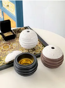 Nahaufnahme moderner, kreativer kugelförmiger Räucherfässchen mit Rillendesign, Gold.