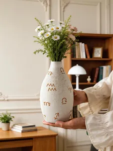 Modern ceramic flower vase with zodiac symbols, elegant white desktop floral container for home decor.