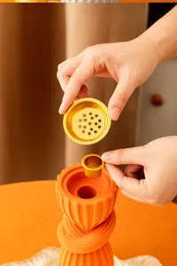 Detailed view of resin incense burner with golden metal filter cup and intricate layers.