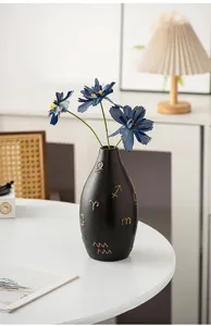 Modern black ceramic flower vase with gold zodiac symbols and blue artificial flowers home decor