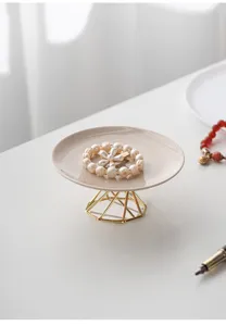 Ceramic jewelry tray detail view showcasing the elegant golden geometric metal display stand.