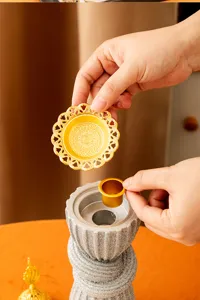 Closeup of resin Arabic incense burner components, showing intricate gold tray and inner cup.