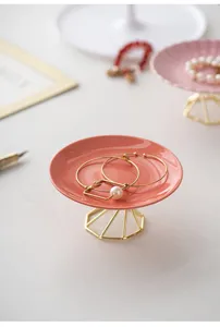 Ceramic jewelry tray with gold metal geometric stand for elegant desktop storage and home decor.