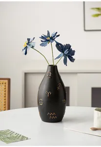 Modern black ceramic vase with golden zodiac symbols, elegant tabletop floral decor for home.