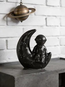 Ceramic astronaut moon figurine detail, black space theme desktop bookshelf decor ornament.