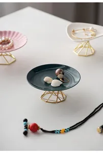 Modern minimalist multi-color ceramic jewelry display tray with gold stand for tabletop decor.