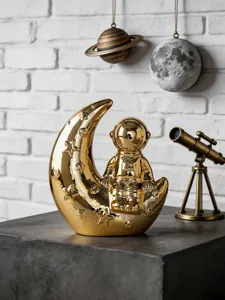 Detail view of the creative gold astronaut moon ceramic ornament, perfect for modern home decor.
