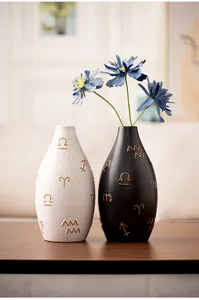 Detail view of modern ceramic vases featuring embossed symbols for elegant table decor.