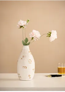 Modern ceramic flower vase with zodiac symbols detail, artistic tabletop decor accent.