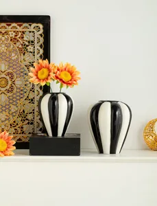 Detailed view of Nordic ceramic vases, black and white striped home decor staging items.