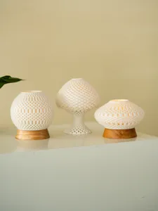 Detailed view of 3D printed ceramic hollow candle holders with wooden base for home decor.