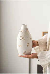 Detailed view of the modern ceramic vase featuring artistic symbols for home decor.