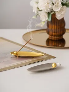 Close-up of modern willow leaf incense holder, elegant metal finish, exquisite desktop detail.
