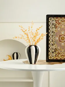 Nordic minimalist smooth black white ceramic vase with gold dried flower branches for home decor.