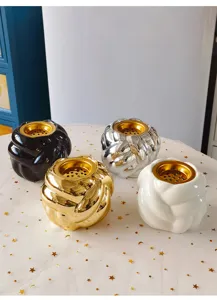 Detailansicht moderner Keramik Duftlampe, runder Räucherhalter in vielen Farben mit Gold.
