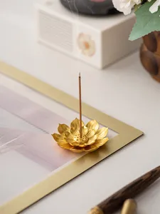 Primo piano dettagliato del bruciatore incenso metallo loto dorato, decoro scrivania elegante.