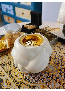 Detailansicht des eleganten modernen weißen Keramik-Weihrauchbrenners mit goldenem Metalleinsatz.