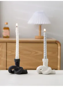 Ensemble de bougeoirs en céramique avec nœud abstrait et bougies spirales pour déco.