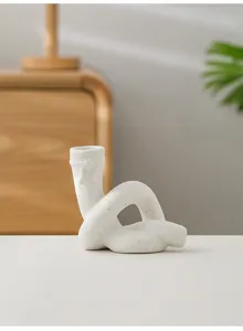 Gros plan sur le bougeoir nœud en céramique blanche mouchetée sur une table en bois.