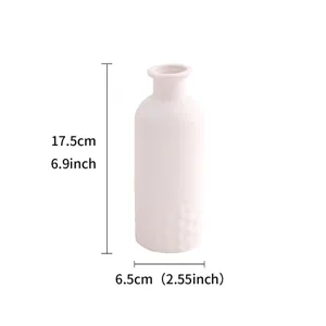 Vue rapprochée d'un vase en céramique blanche montrant sa texture et ses dimensions.