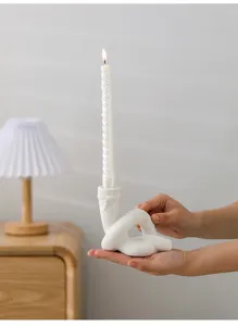 Gros plan détaillé d'un bougeoir en céramique blanche avec une bougie torsadée pour déco.